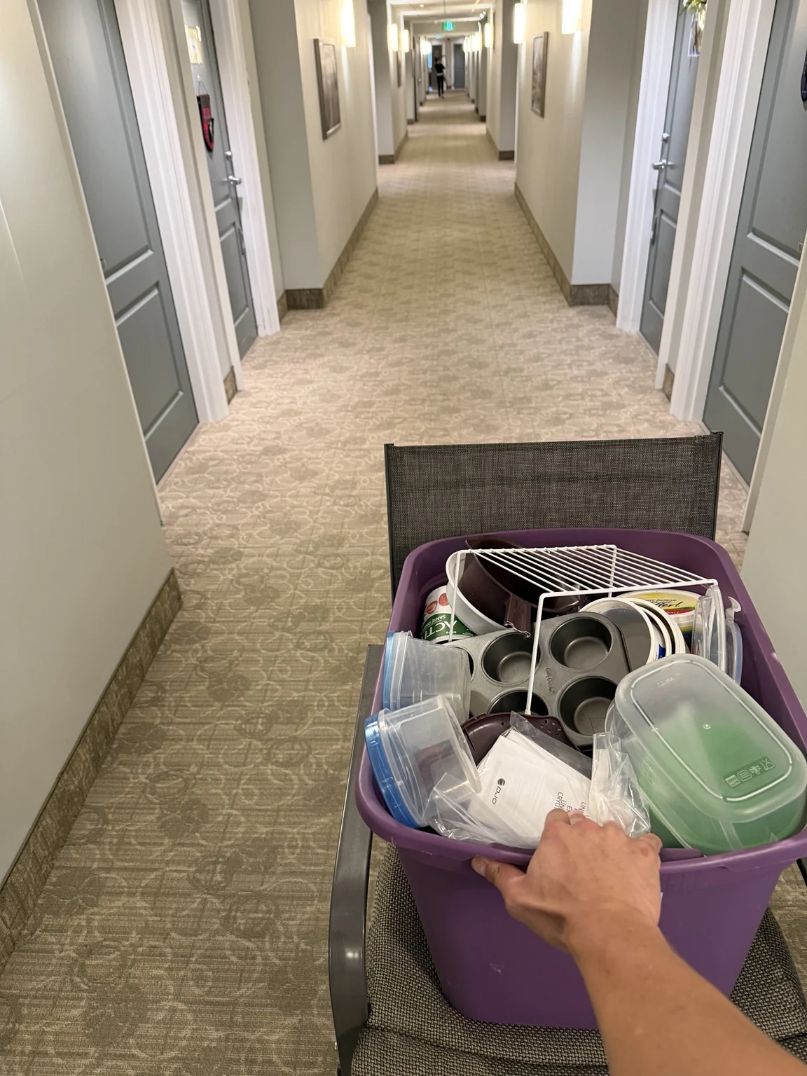 Household items being moved through a condo hallway